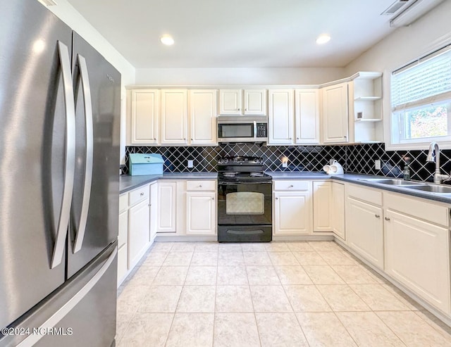 kitchen with sink, light tile patterned flooring, decorative backsplash, and appliances with stainless steel finishes