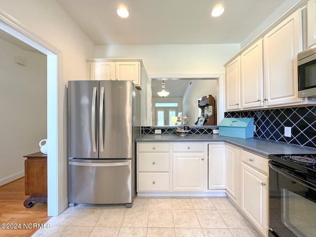 kitchen featuring decorative light fixtures, stainless steel appliances, light tile patterned floors, tasteful backsplash, and white cabinetry