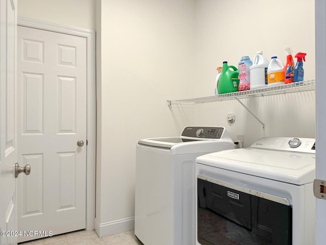 laundry area featuring light tile patterned flooring and washing machine and clothes dryer