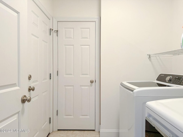 laundry room with independent washer and dryer and light tile patterned floors