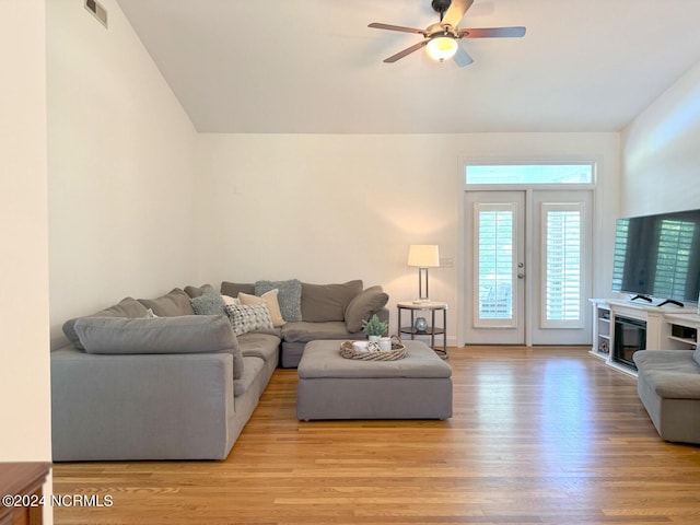 living room with lofted ceiling, ceiling fan, and light hardwood / wood-style flooring