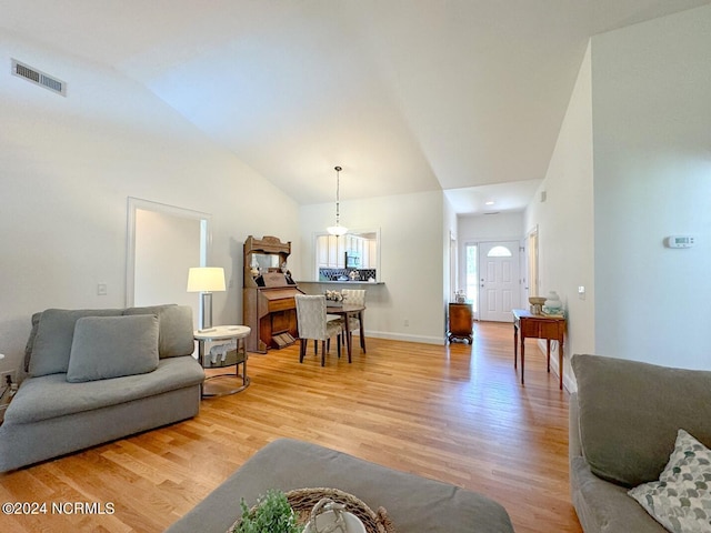 living room featuring lofted ceiling and light hardwood / wood-style flooring