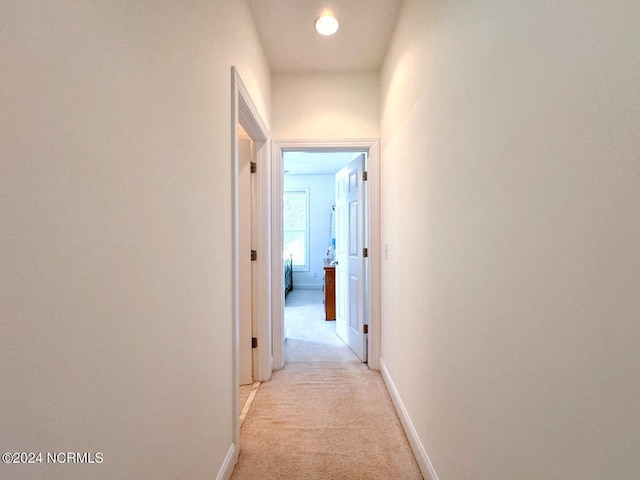 corridor featuring light colored carpet