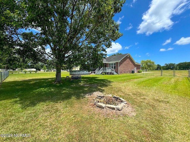 view of yard with an outdoor fire pit and a pool side deck