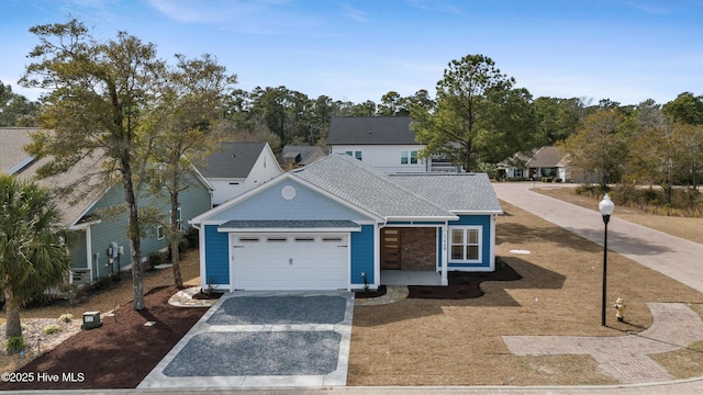 view of front facade featuring a garage, driveway, a shingled roof, and a residential view