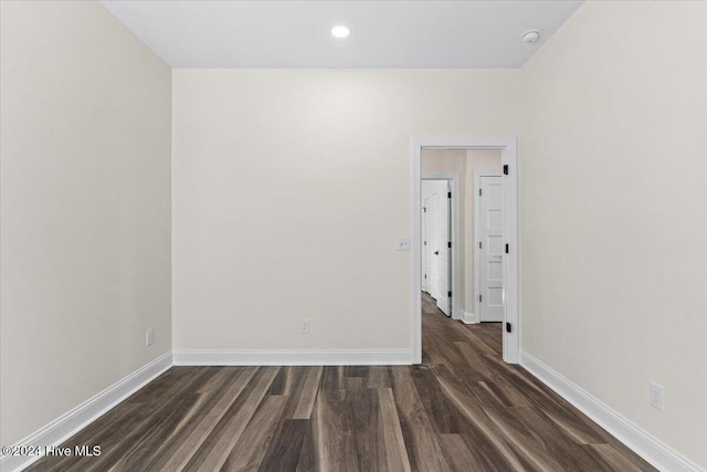 unfurnished room featuring dark wood-style flooring, recessed lighting, and baseboards