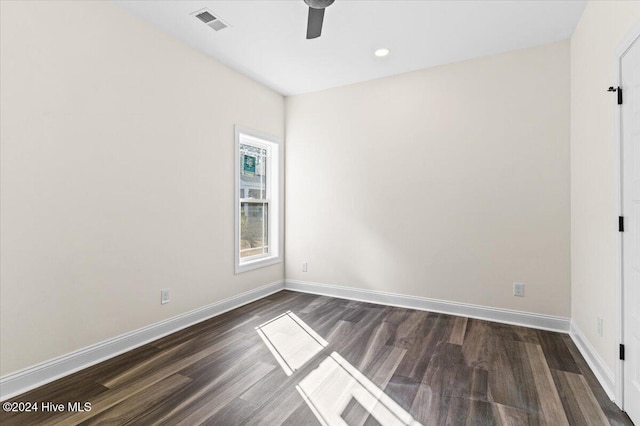 unfurnished room with baseboards, visible vents, ceiling fan, and dark wood-style flooring