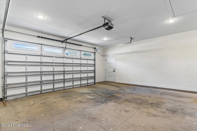 parking garage with baseboards and a garage door opener