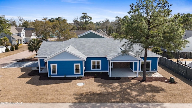 ranch-style house with a shingled roof and fence