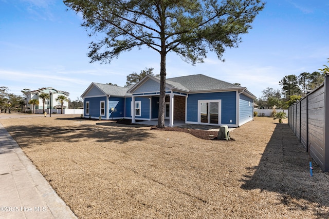 view of front of home with a shingled roof and fence