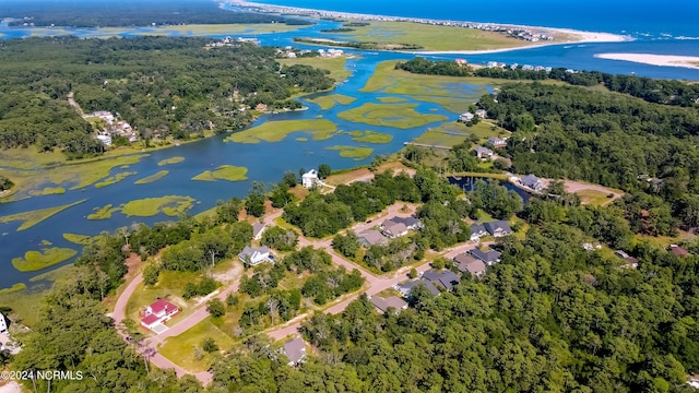 drone / aerial view with a water view and a wooded view