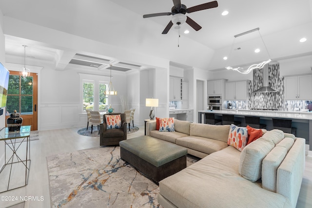 living room with coffered ceiling, ceiling fan, crown molding, beamed ceiling, and light hardwood / wood-style floors