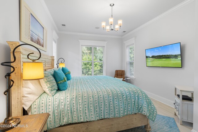 bedroom with an inviting chandelier, light hardwood / wood-style floors, and ornamental molding