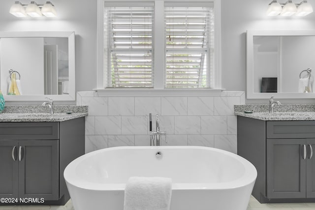 bathroom featuring vanity, tile walls, and a bathing tub