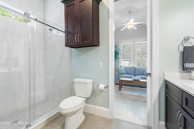 bathroom featuring ceiling fan, tile patterned floors, toilet, a shower with door, and vanity