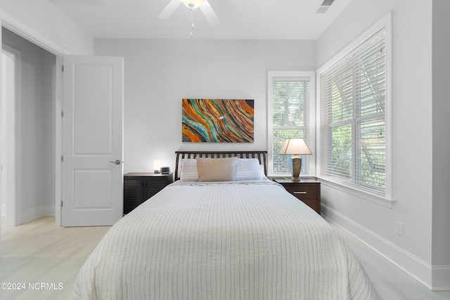 bedroom featuring multiple windows, light wood-type flooring, and ceiling fan