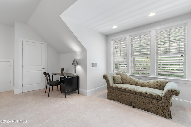 living area with light carpet and vaulted ceiling