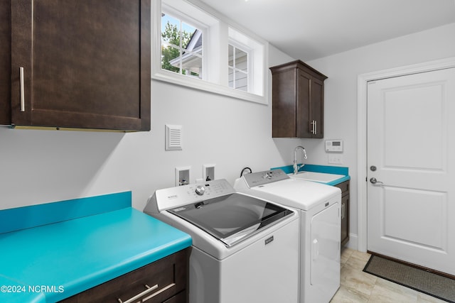 laundry area featuring cabinets, independent washer and dryer, and sink