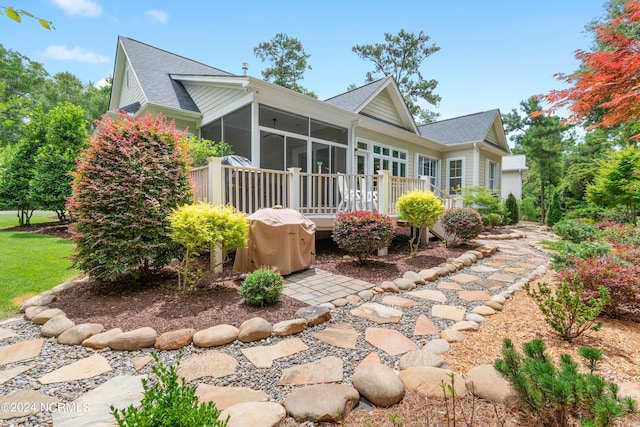 back of house featuring a wooden deck and a sunroom