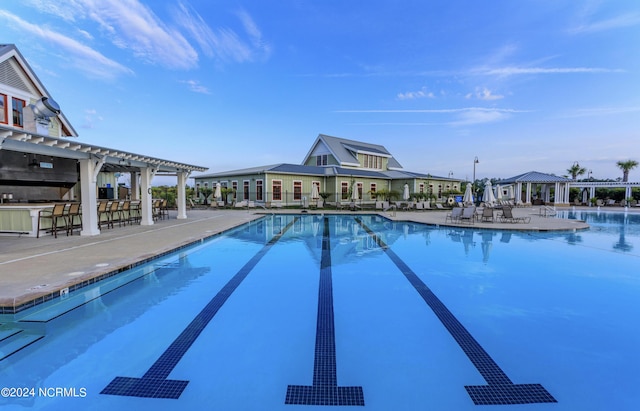 view of swimming pool featuring a patio area and exterior bar