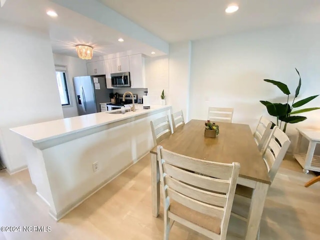 kitchen with white cabinetry, sink, a notable chandelier, and appliances with stainless steel finishes