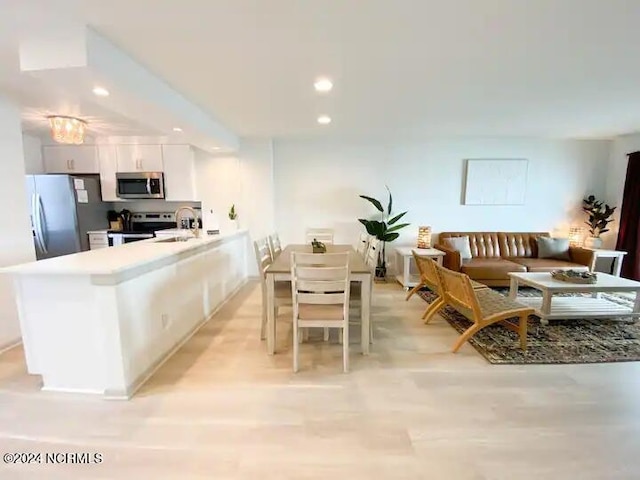 kitchen featuring a breakfast bar, white cabinetry, sink, and appliances with stainless steel finishes