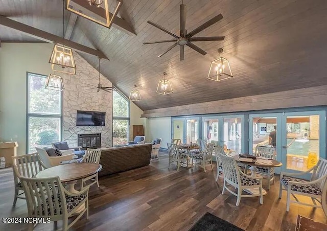 living room with wooden ceiling, dark wood-type flooring, high vaulted ceiling, ceiling fan with notable chandelier, and a stone fireplace