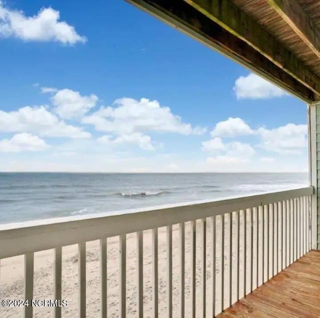 balcony featuring a water view and a view of the beach