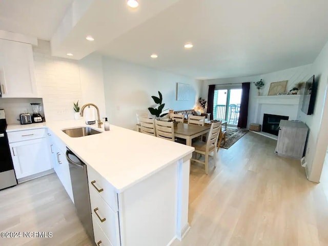 kitchen with kitchen peninsula, light wood-type flooring, sink, dishwasher, and white cabinets