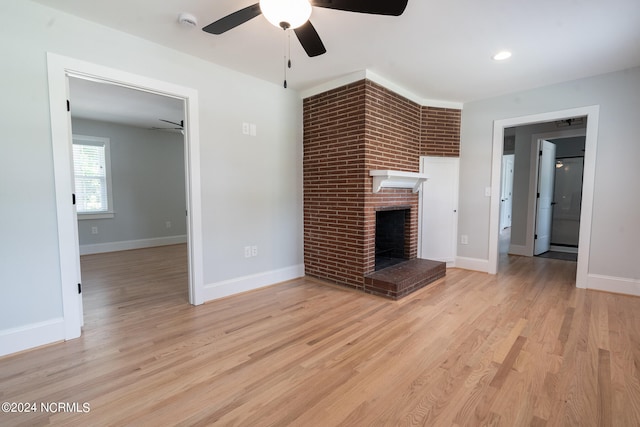 unfurnished living room featuring ceiling fan, light hardwood / wood-style floors, and a fireplace