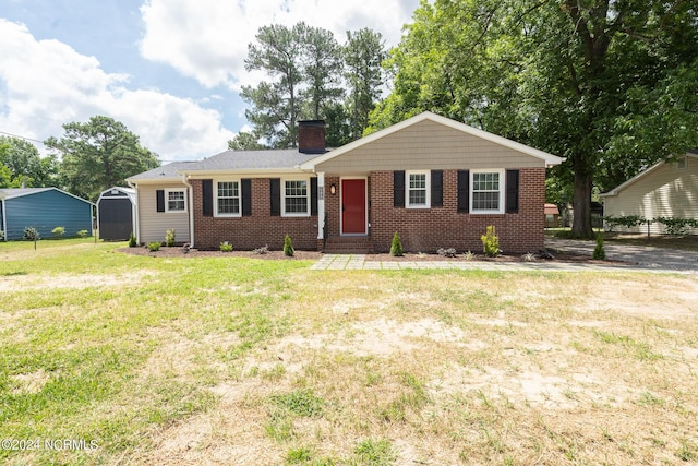 ranch-style home featuring a shed and a front lawn