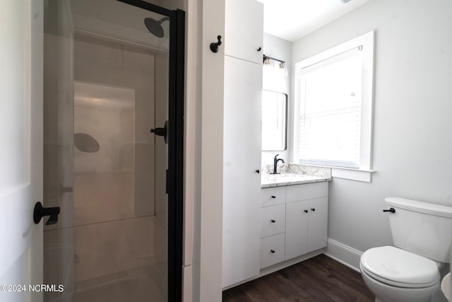 bathroom featuring toilet, an enclosed shower, vanity, and hardwood / wood-style flooring