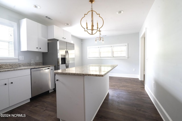 kitchen featuring a kitchen island, decorative light fixtures, white cabinetry, a notable chandelier, and stainless steel appliances