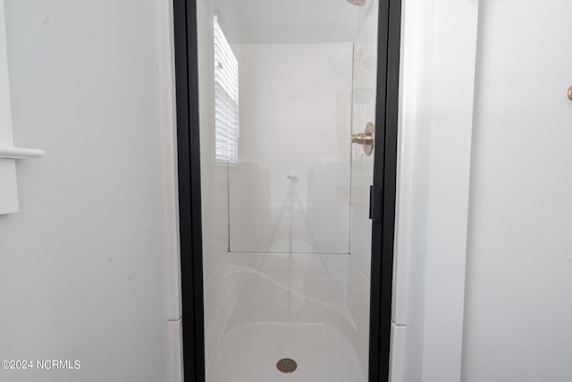 bathroom with a shower with door