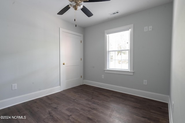 spare room featuring dark hardwood / wood-style flooring and ceiling fan