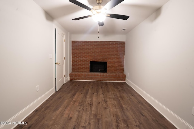 unfurnished living room with a fireplace, dark hardwood / wood-style floors, and ceiling fan