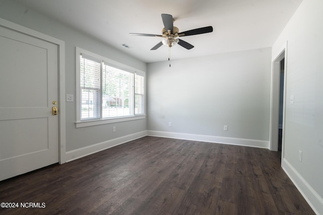 empty room with ceiling fan and dark hardwood / wood-style flooring