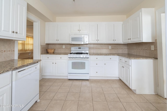 kitchen with white cabinetry, light stone counters, backsplash, and white appliances