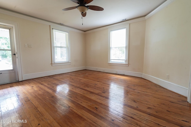 spare room with crown molding, plenty of natural light, and hardwood / wood-style floors