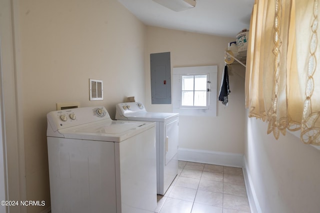 washroom featuring electric panel, separate washer and dryer, and light tile patterned floors