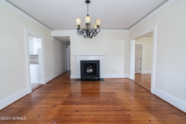 unfurnished living room featuring an inviting chandelier, hardwood / wood-style floors, and ornamental molding