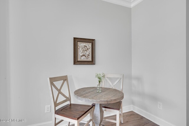 dining space featuring baseboards, crown molding, and wood finished floors