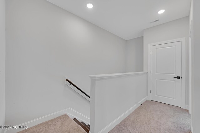 hallway with carpet, visible vents, recessed lighting, an upstairs landing, and baseboards