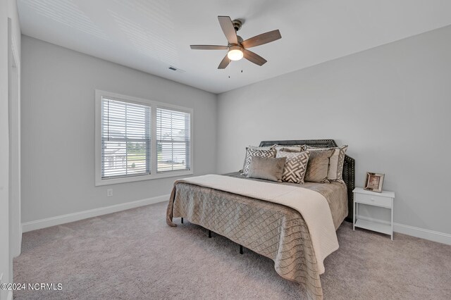 bedroom featuring visible vents, baseboards, a ceiling fan, and carpet