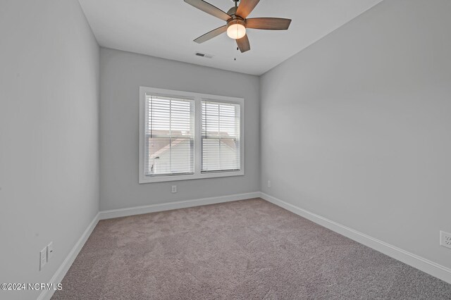 spare room featuring ceiling fan, baseboards, visible vents, and carpet floors