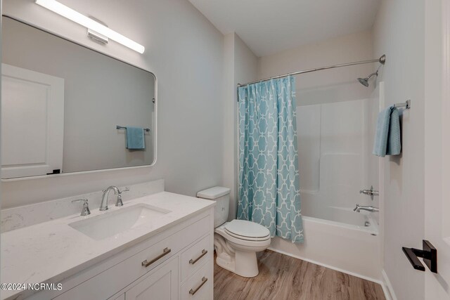 bathroom with toilet, shower / bathtub combination with curtain, vanity, and wood finished floors