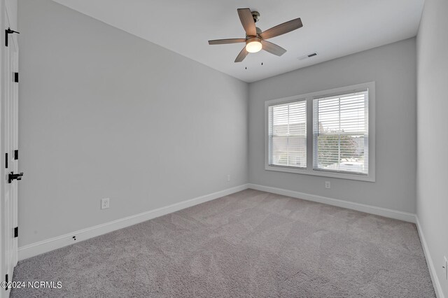 spare room featuring light carpet, baseboards, and visible vents