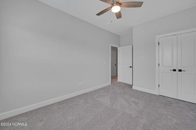 unfurnished bedroom with a closet, carpet flooring, baseboards, and ceiling fan