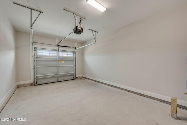 garage featuring a garage door opener and baseboards