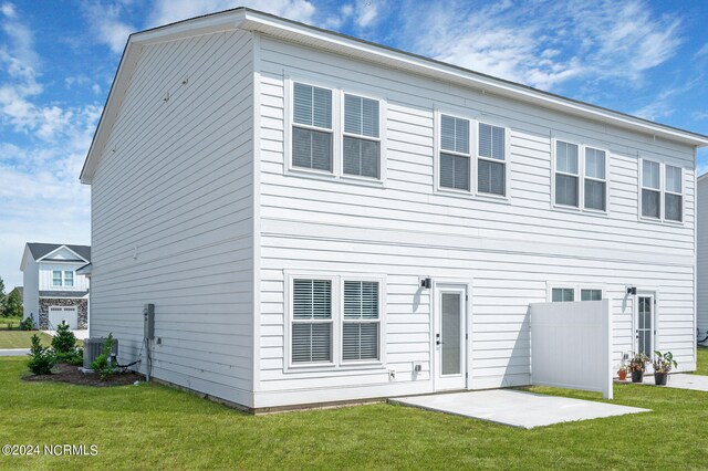 back of house with cooling unit, a patio, and a lawn